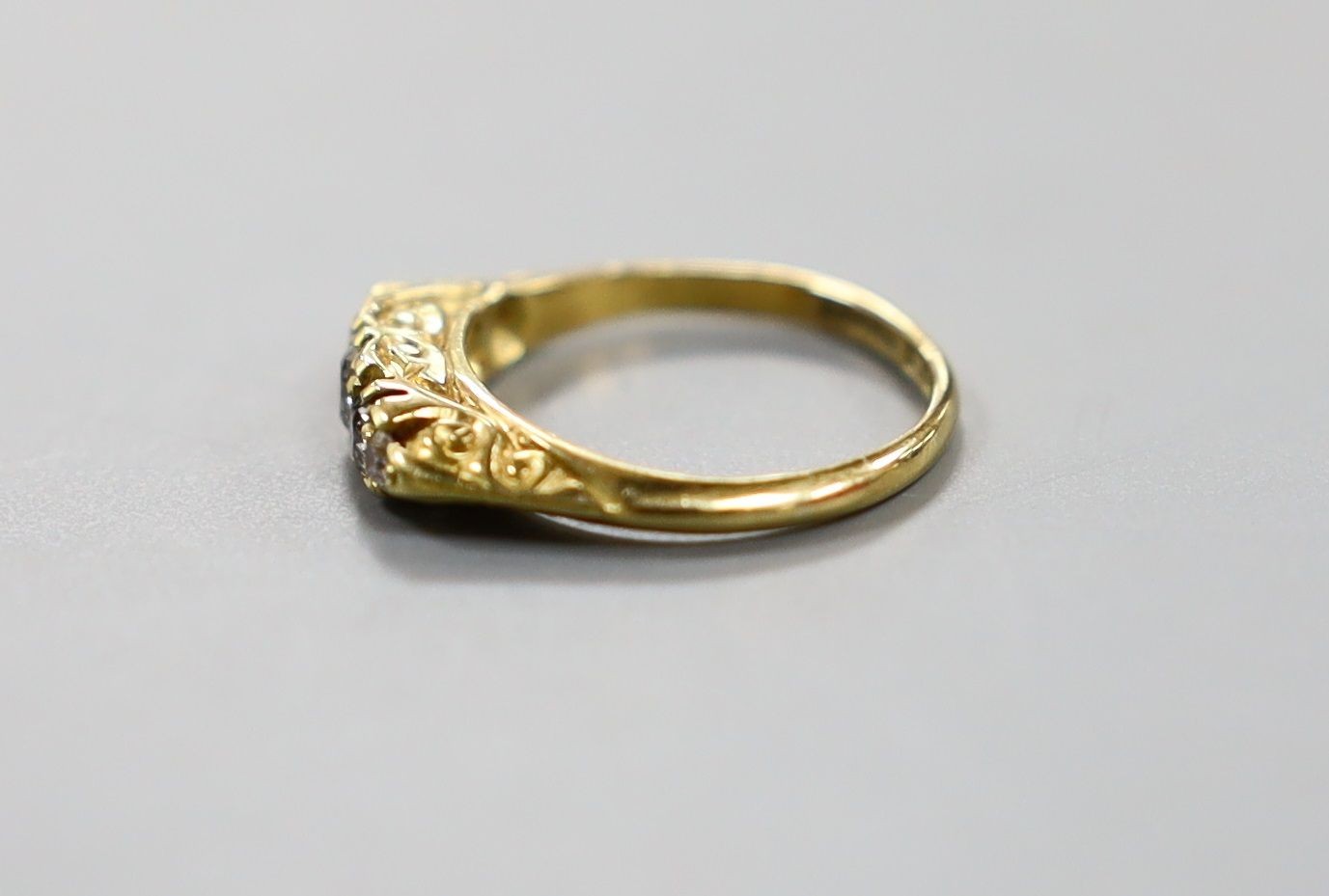 An early 20th century 19ct gold and graduated five stone diamond set half hoop ring, size G, gross weight 2.8 grams.